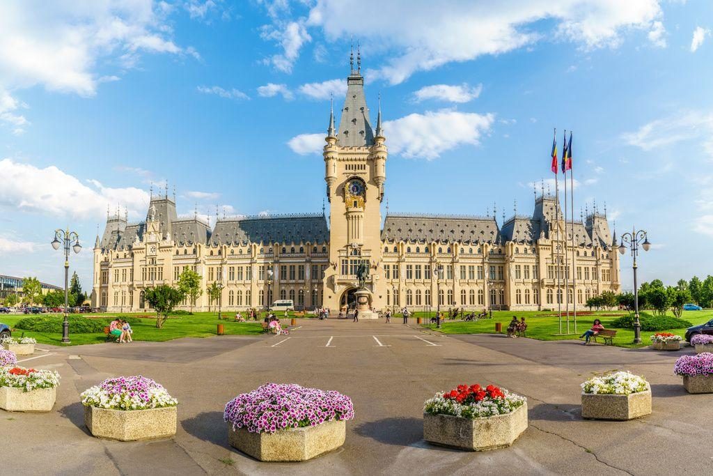 The Palace of Culture in Iași, with planters of flowers on the square in front of it